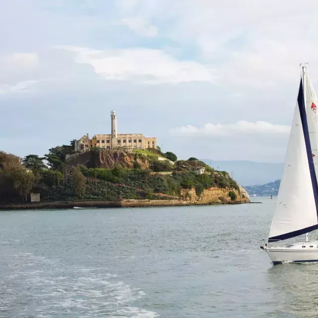 A sailboat passes in front of 阿尔卡特拉斯岛 Isl和 in 贝博体彩app.